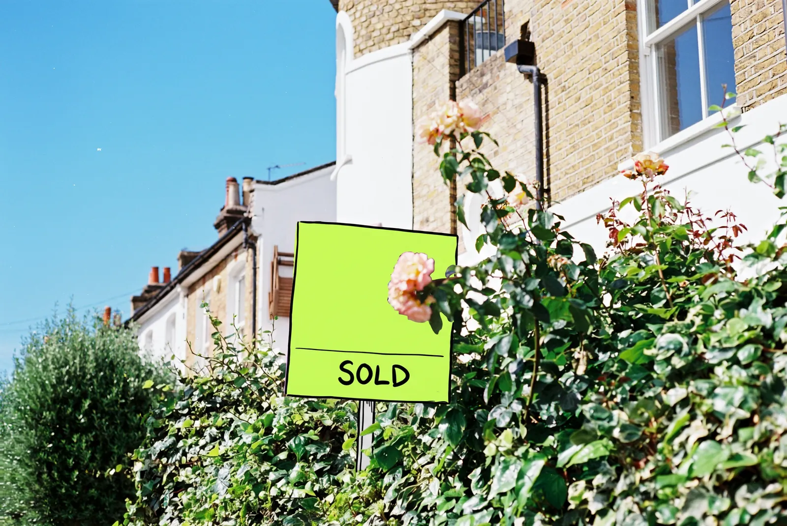 A SOLD sign in front of a house, the sign drawn in lime ink
