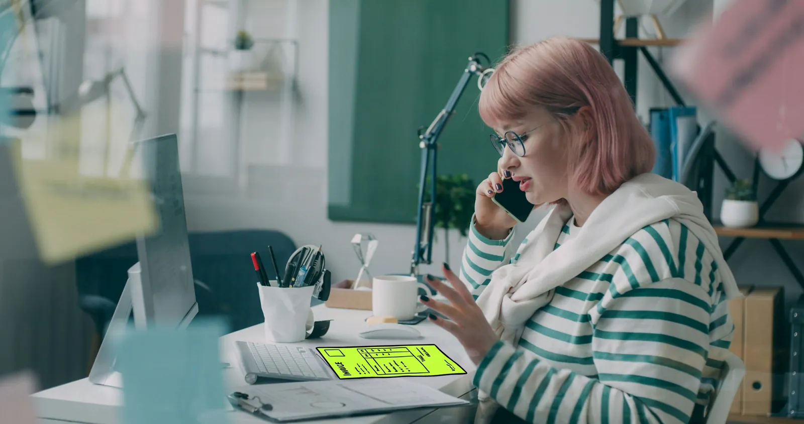 A credit controller on a phone call at her desk, the invoice drawn in lime ink